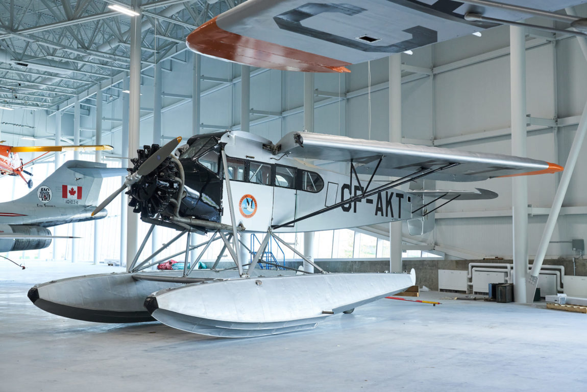 a vintage aircraft on floats sits inside a museum
