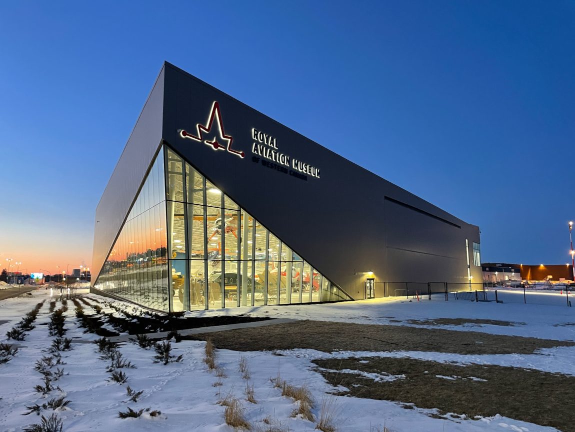 exterior of a large metal and glass building at dusk