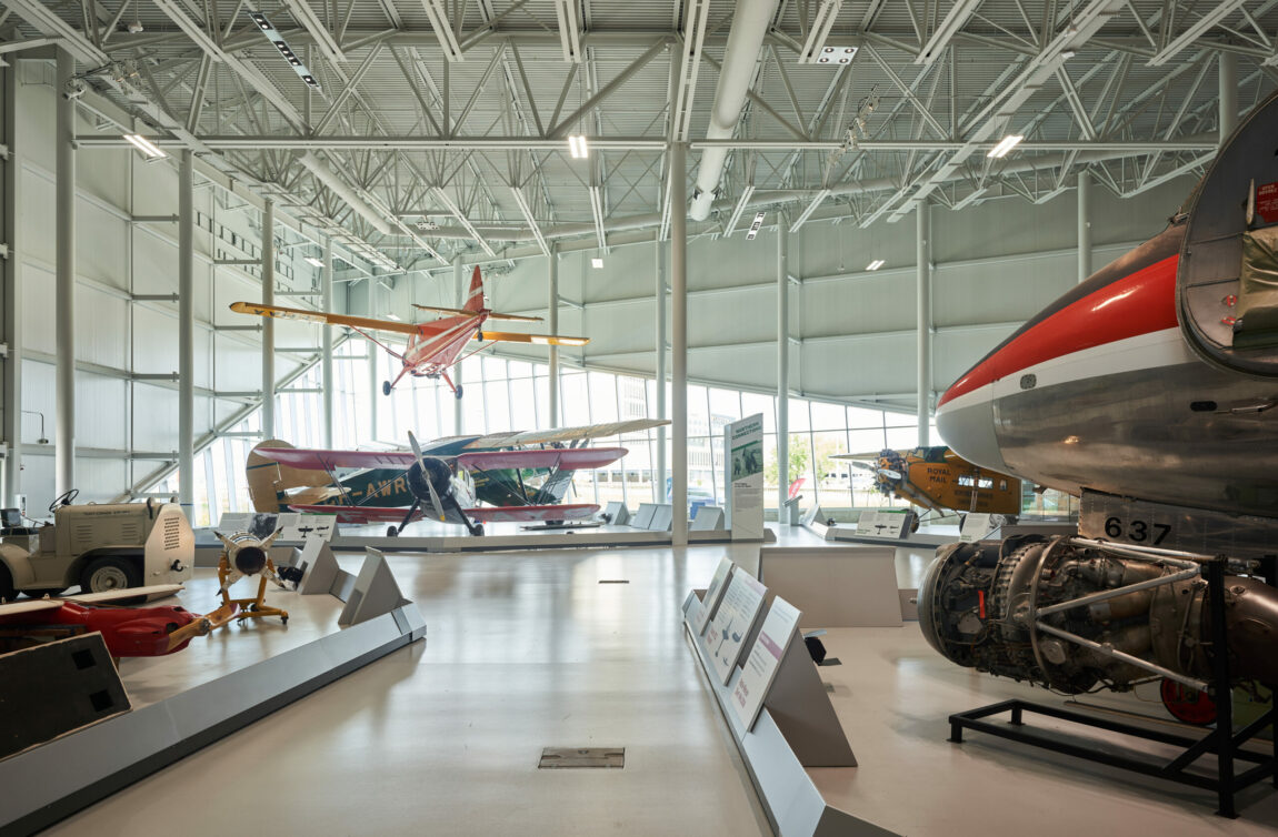 Interior image of the Royal Aviation Museum from the ground floor. Visible is one of the museum's suspended aircraft, the de Havilland Canada Beaver, positioned above the Bellanca Aircruiser. On the right of the photo, the nose of the Vickers Viscount is visible, behind it, the nose of the Fokker Super Universal is visible.