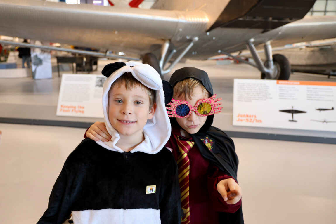 Two kids in costume stand in front of the Junkers Ju-52 during the Royal Aviation Museum's Halloween with Hobbs event.