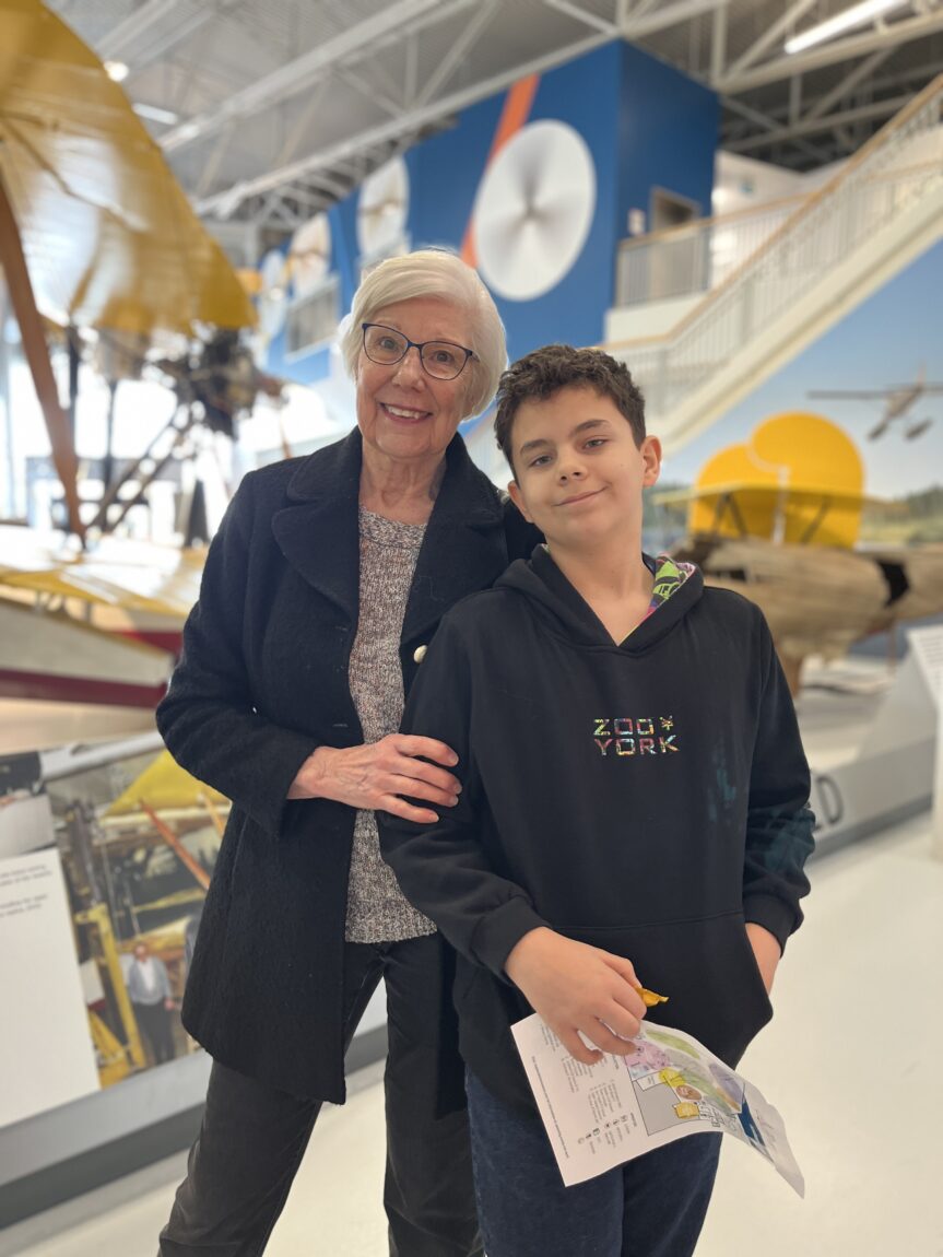 A boy poses with his grandmother in front of the Vickers Vedette at the Royal Aviation Museum of Western Canada