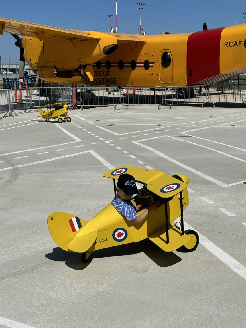 A young child takes a Tiger Moth pedal plane for a spin Aviation Plaza at the Royal Aviation Museum of Western Canada