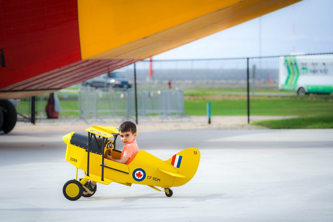 A boy sits in a Tiger Moth pedal plane at the Royal Aviation Museum of Western Canada