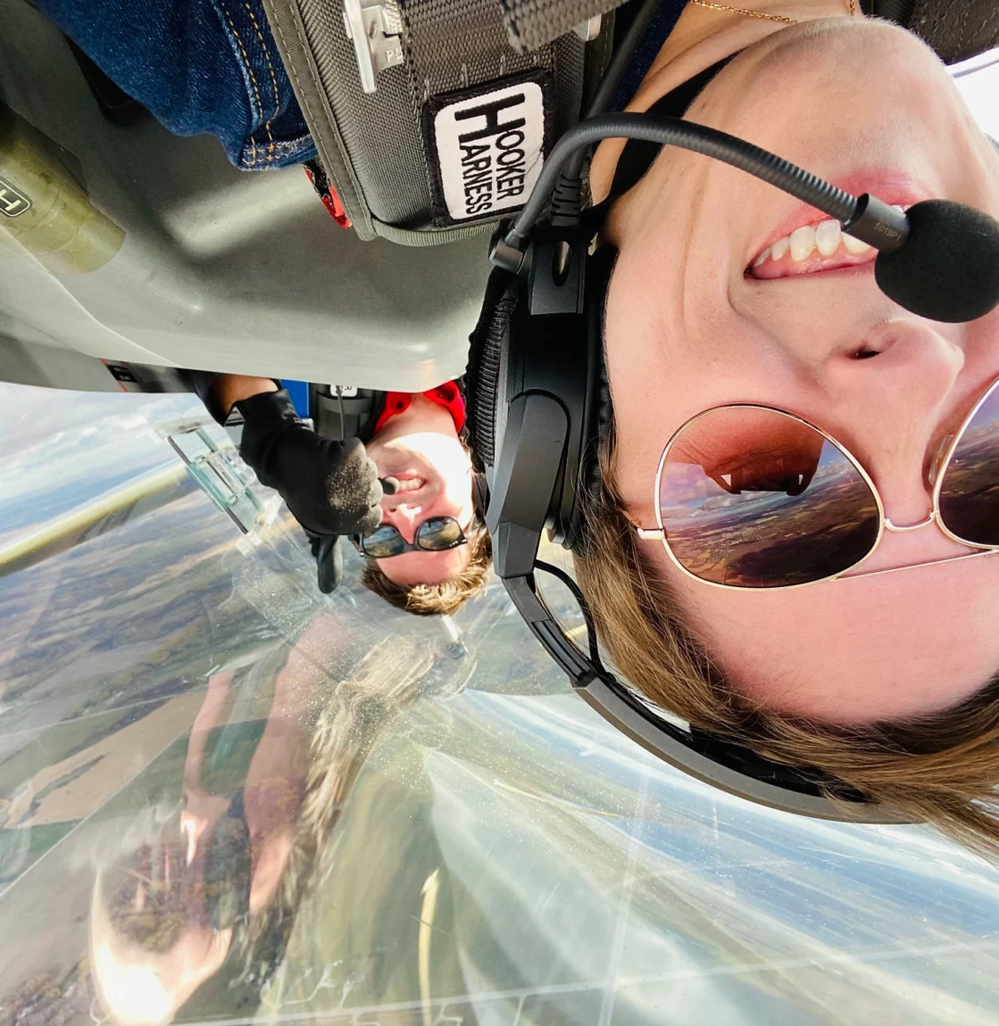 Close up selfie of pilot Luke Penner and a passenger flying inverted in Luke's aerobatic plane