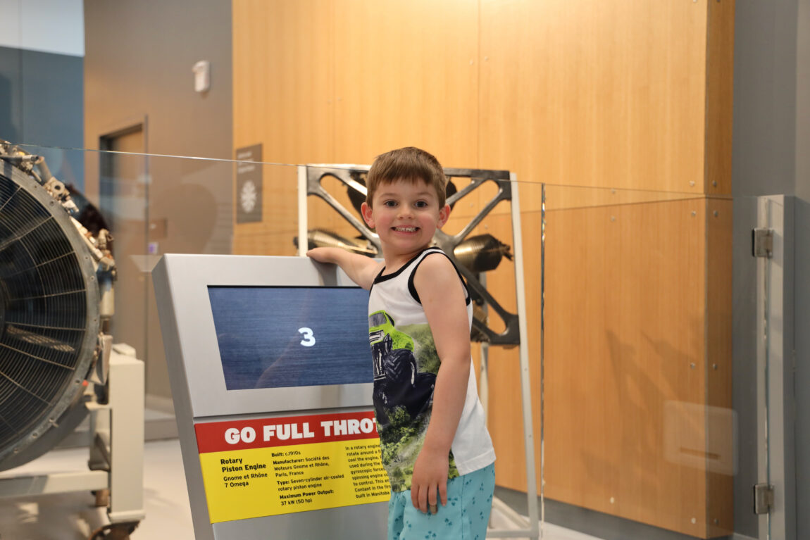 a young boy plays with an engine simulator