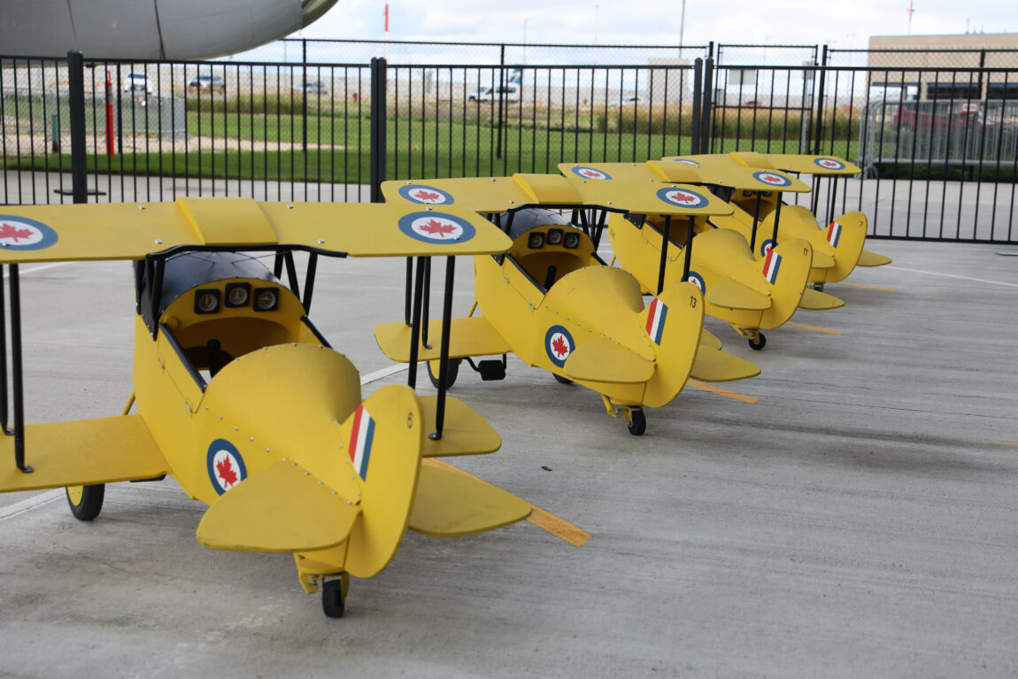 A row of wooden, yellow pedal planes.