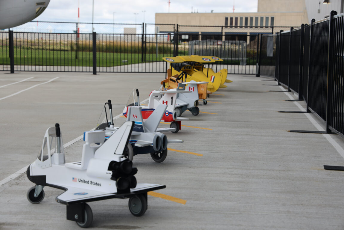 A lineup of pedal and push planes modelled after fighter jets and bush planes at the Royal Aviation Museum of Western Canada