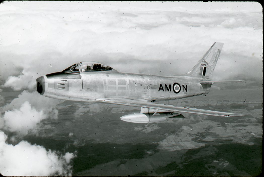 A Canadair F-86 Sabre with RCAF markings in flight. Black and white image taken from a parallel aircraft.