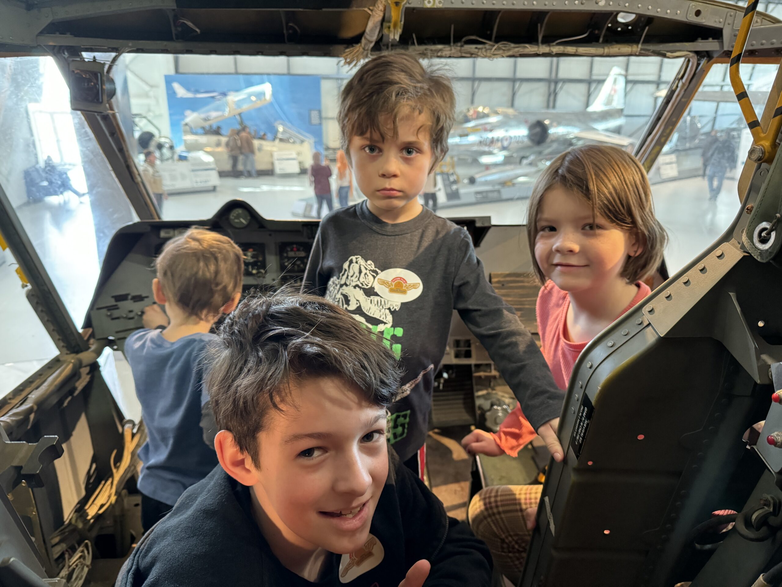 Four young child pose for the camera from the cockpit of a small plane