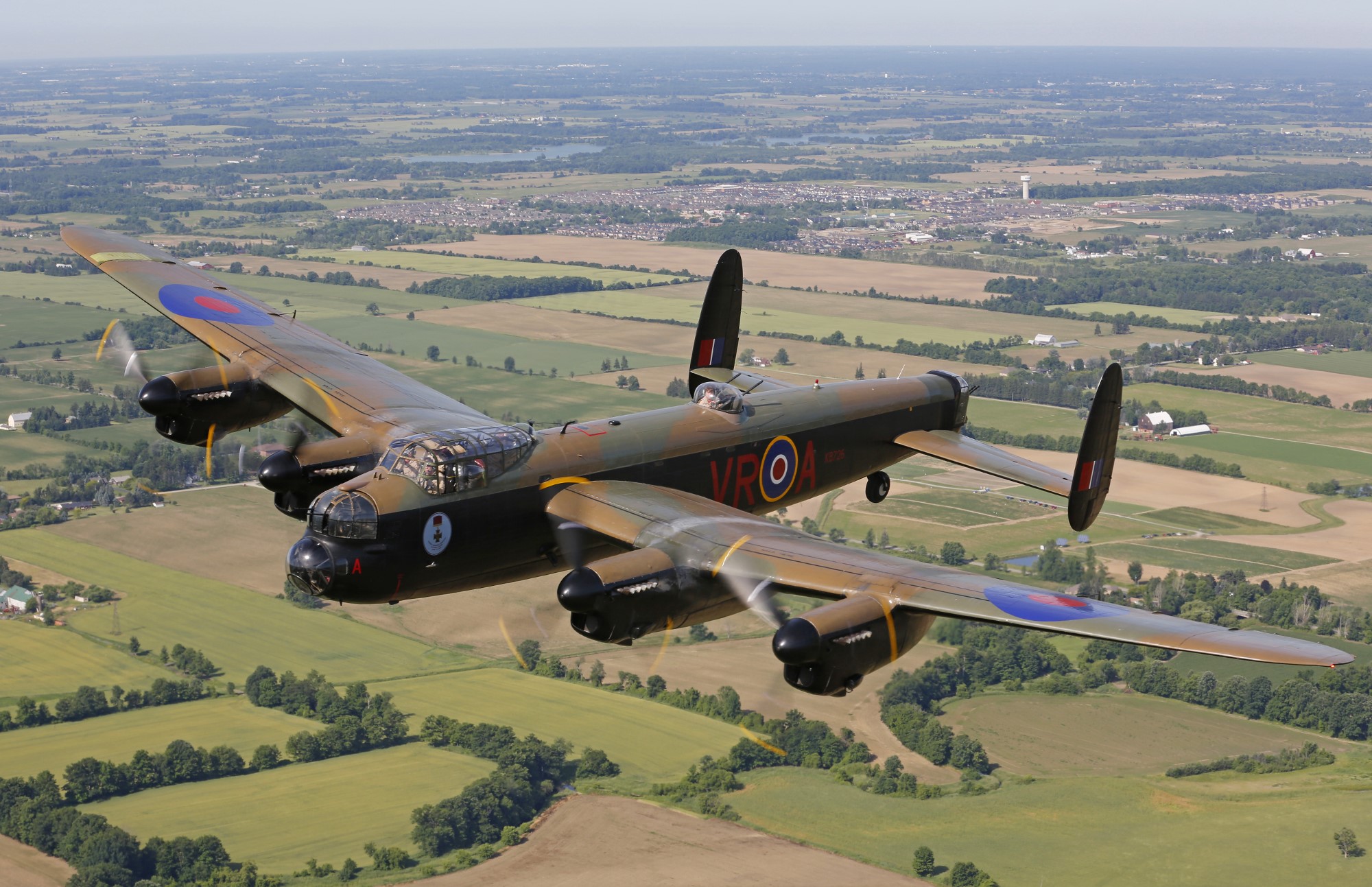 Avro Lancaster aircraft flying over patchwork fields