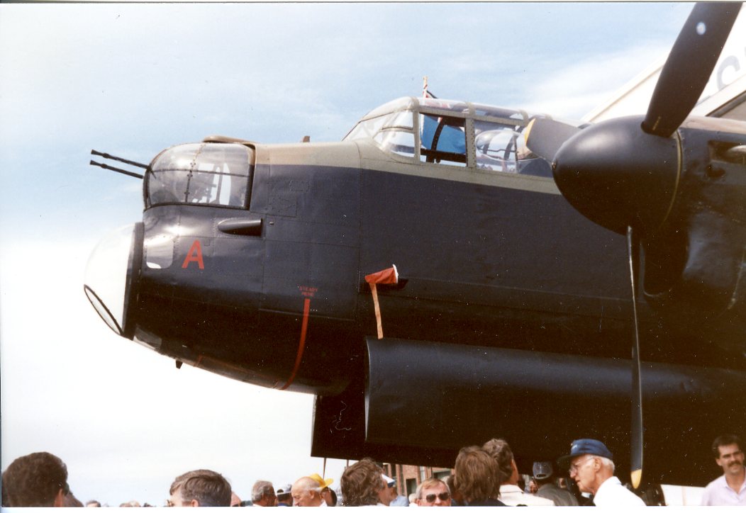 The nose of Avro Lancaster C-GVRA, seen from its left side. In the bottom of the frame, a crowd of tourists are partly visible.