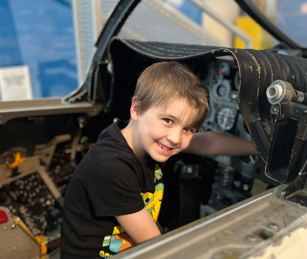 child sitting in cockpit simulator